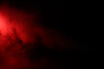 Fototapeta premium Beautiful smoke in neon light on dark background, space for text