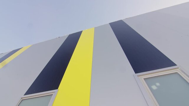 Clean geometric lines and vibrant wall color accents on building facade. Contemporary exterior styling creates strong dynamic visual appeal