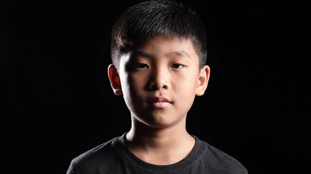 Portrait of a Young Asian Boy on Black Background