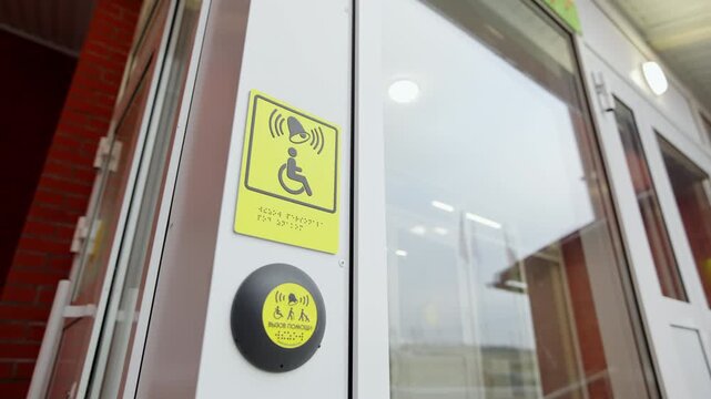 Entrance door frame features tactile information and assistance call device. Functional design creates welcoming public facility entrance