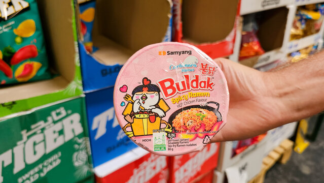 Hand holding samyang buldak carbonara spicy ramen cup