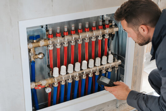 T&eacute;cnico revisa el sistema de calefacci&oacute;n en un edificio en construcci&oacute;n durante el d&iacute;a