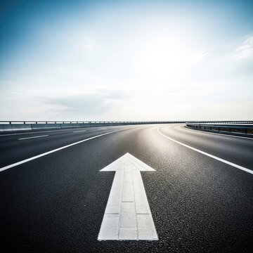 A wide asphalt road stretches toward a distant horizon under a bright sky, featuring a white painted arrow pointing forward on the pavement, perspective, destination, line