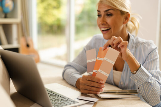 Woman Assesses Color Samples at Her Desk While Working on a Freelance Project in a Small Home Office
