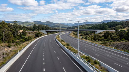 Obraz premium Scenic Highway with Cars Through Mountain and City Landscapes Under a Dramatic Sky