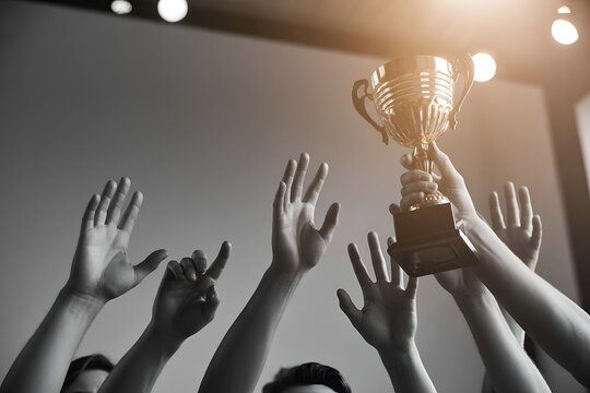 Group of hands reaching up holding golden winner trophy cup victory success achievement business award presentation