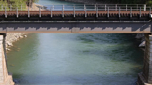 Scenic railway bridge spanning a tranquil flowing river