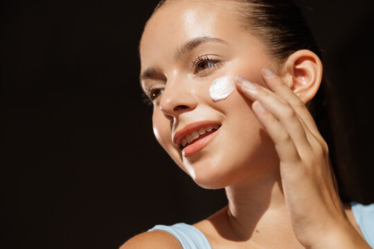 Young Woman Applying Facial Cream for Skincare Routine