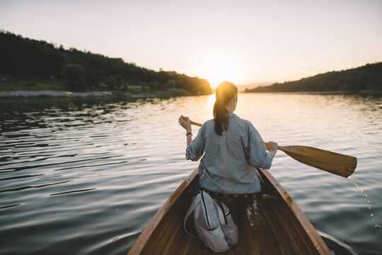 Solo canoe trip on tranquil lake at golden hour