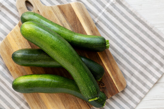 Raw Green Organic Zucchini on a Wooden Board, top view. Copy space.