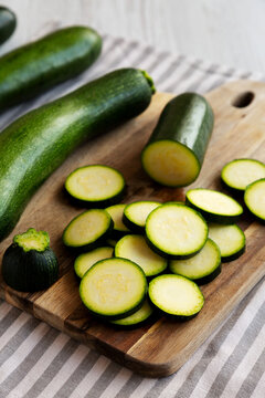 Raw Green Organic Zucchini on a Wooden Board, side view.