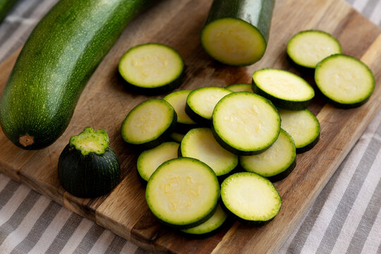 Raw Green Organic Zucchini on a Wooden Board, side view.