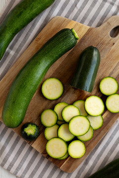Raw Green Organic Zucchini on a Wooden Board, top view.