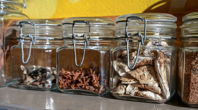 Storage jars featuring wire bail closures for dried goods and spices. Clear glass containers with rubber gasket seals for herbs and mushrooms.