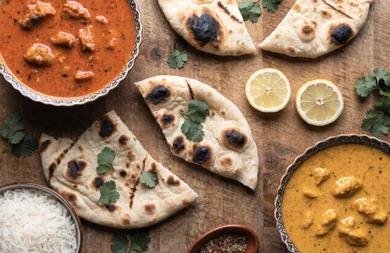 Aromatic indian curry paired with soft naan bread beautifully arranged on a wooden board showcasing the vibrant flavors of south asian cuisine ideal for sharing with friends and family