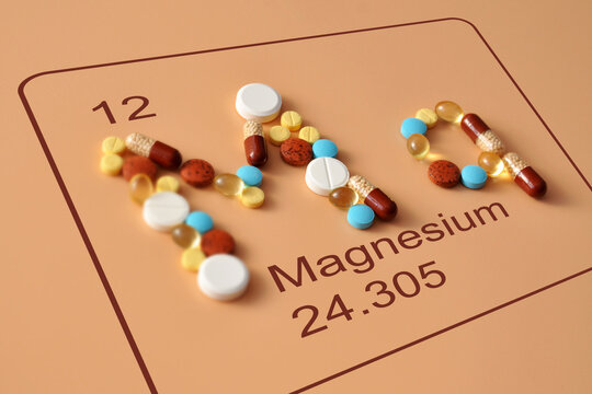 Magnesium Element Symbol Made from Colorful Supplements on Peach Background