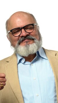 Indian Asian elderly businessman with a beard, wearing a suit, standing happily against a white background holding a fan of money in his hands and showing a success gesture with his fist