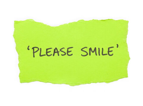 Bright green sticky note with the text please smile written on the paper sheet