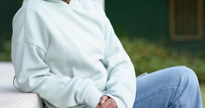 African-American child sitting on porch step camera receding causing smiling chin resting on hand