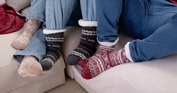 Family parents and child leaning on sofa as camera pulling back, wearing Santa hats, sharing warmth