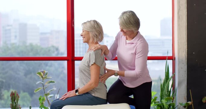 Two women therapist placing hands on patient's back on padded bench, checking posture, copy space