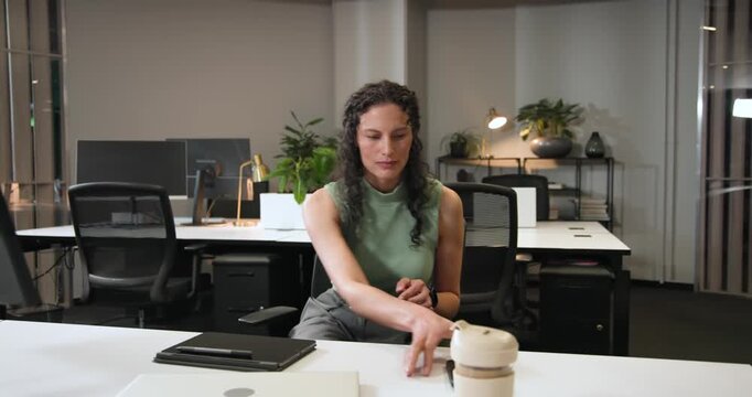 African American woman scrolling tablet at desk, using stylus, answering call, rising while talking