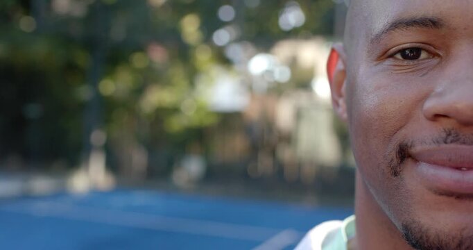 Adult male in tank top seeing camera, smiling wider, moving closer on blue court, copy space