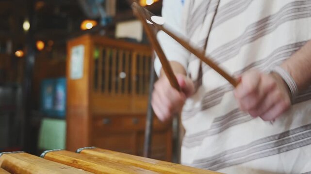 Hands Playing a Traditional Wooden Xylophone in Taiwan