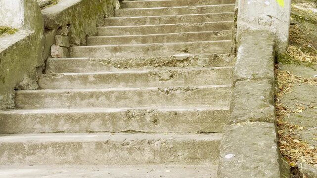 Old concrete stairs rise quietly along a stone wall in Simferopol, Crimea. The weathered steps evoke a peaceful, nostalgic feeling of lonely calm.