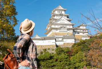 Happy woman traveler  with hat  and himeji castle on vacation in japan © xamnex