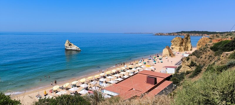 Praia da Rocha beach with umbrellas and red beach bar roof