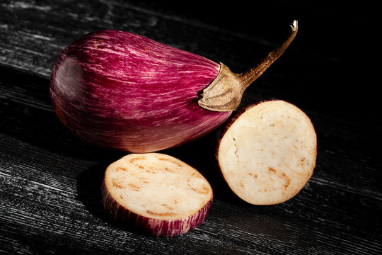 sliced jewel marble eggplant on black wood background