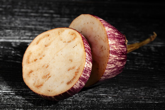 sliced jewel marble eggplant on black wood background