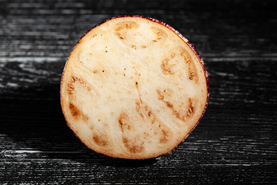 sliced jewel marble eggplant on black wood background