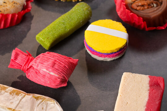 Colorful traditional Mexican candies including obleas and tamarindo served on dark slate
