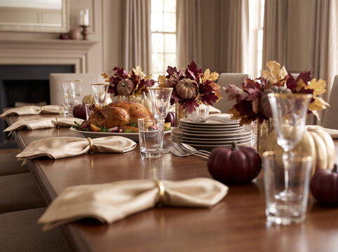 Thanksgiving dinner table setting with roasted turkey and fall decorations