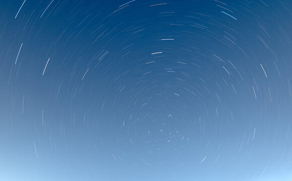 View of star trails forming circular patterns in the night sky above Jahanian, Pakistan.