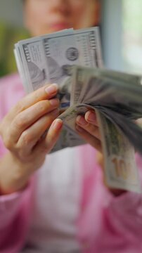 Woman counting US Dollar bills, close-up. Concept of investment and success