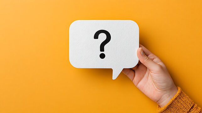 A hand holds a speech bubble sign with a question mark on a yellow background. Represents uncertainty or frequently.