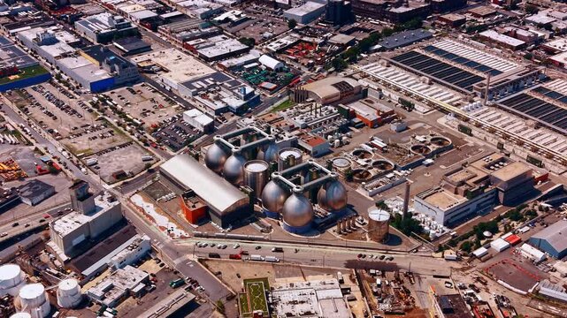New York City, specifically the industrial and urban landscape of Greenpoint, Brooklyn. View on the Newtown Creek Wastewater Treatment Plant with stainless steel egg-shaped anaerobic digesters.