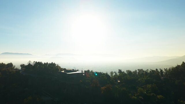 Aerial Horizontal Zooming Out View of San Cristobal Hilltop Building and Misty City Valley, Chile