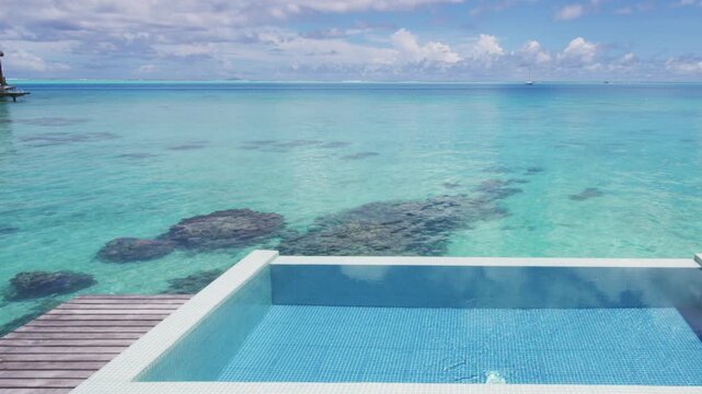Luxury pool. Infinity pool over tropical ocean coral lagoon travel vacation background in Slow motion.