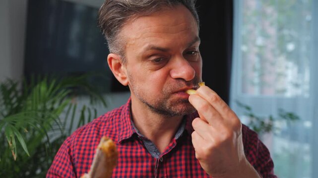 Junk food advertisement concept. Man eating fried chicken, enjoying fast food.