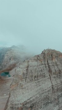 FPV drone flying along the surface of mountain cliffs of Cristallo mountain.