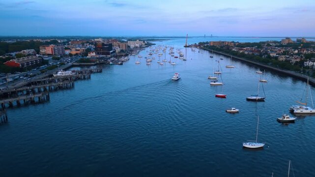 Many vessels are on the waterscape of Sheepshead Bay. View on the cityscape of Brooklyn, New York City at sunset.