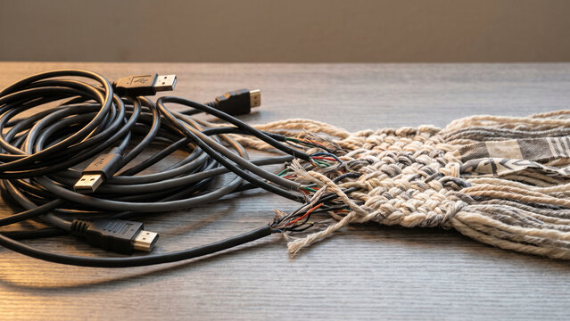 Tangled Black Cables Transitioning into a Handwoven Natural Fiber Network
