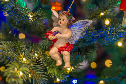 Close up of a Christmas Ornament of a Baby Angel or Cherub Hanging on a Christmas Tree