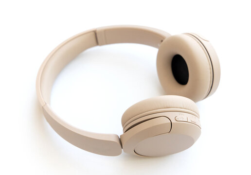 Modern beige wireless headphones isolated on a white background