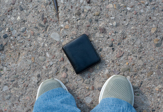 The lost wallet on the street, forgotten black leather object