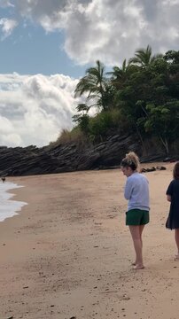 People Enjoying Beach Activities at Feiticeira Beach in Ilhabela, Brazil